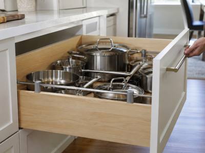 A deep kitchen drawer pulled out and holding pots and pans.